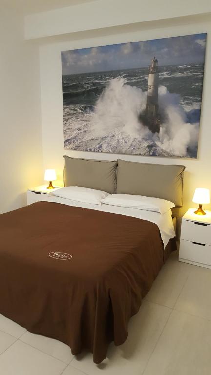 a bedroom with a bed with a picture of a lighthouse at Orchidea Beach in Civitanova Marche