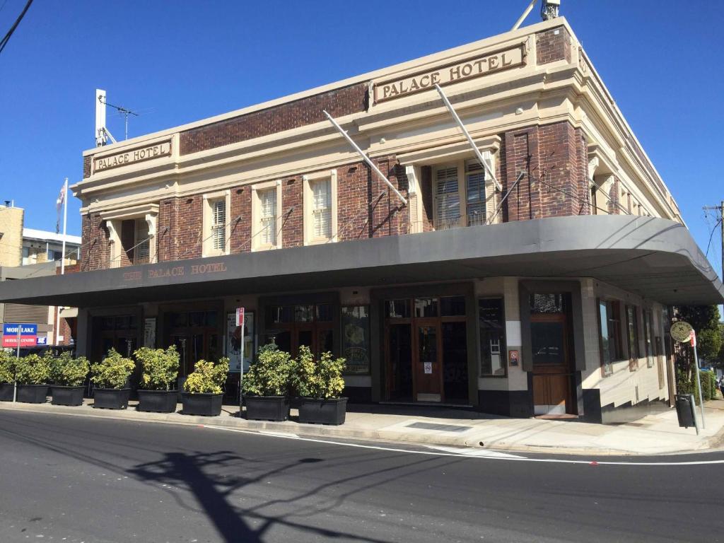 a building on the corner of a street with plants at Palace Hotel Mortlake Sydney in Sydney