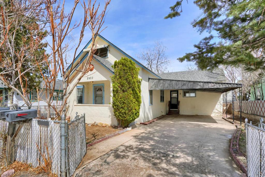 a white house with a fence in front of it at Finding Tranquility in Colorado Springs