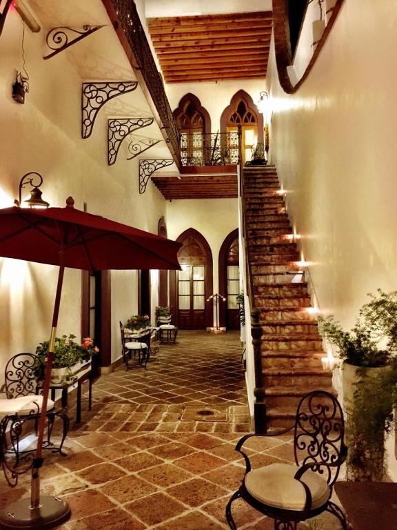 a building with a staircase with chairs and an umbrella at El Serafin Hotel Boutique in Querétaro