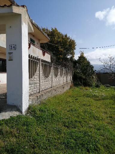 a fence in the grass next to a house at Casa in COLLINA DI REGGIO Calabria in Reggio di Calabria