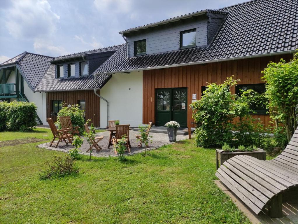 una casa con un patio con sillas y mesas en Gästehaus Kuck, en Monschau