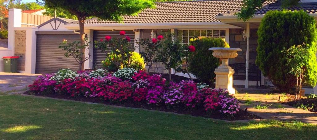 une maison avec un jardin de fleurs devant elle dans l'établissement Golden Retreat, à Golden Grove