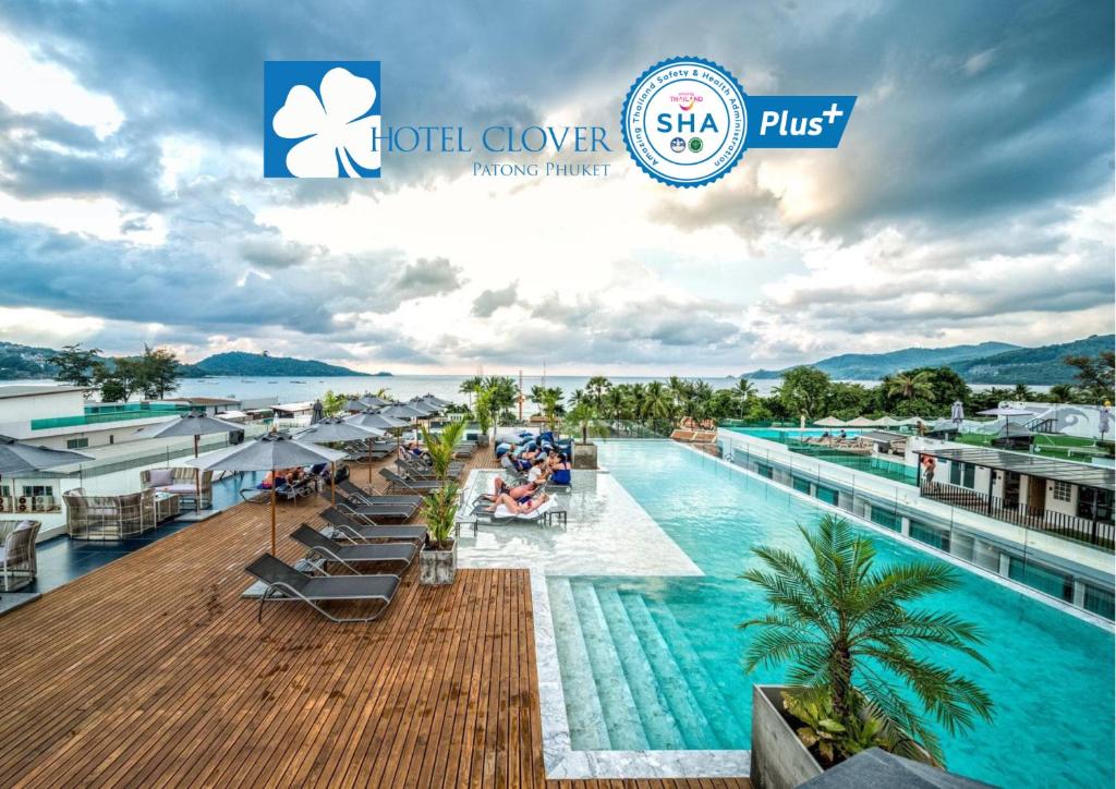 
a beach with a lot of tables and chairs and umbrellas at Hotel Clover Patong Phuket - SHA Plus in Patong Beach
