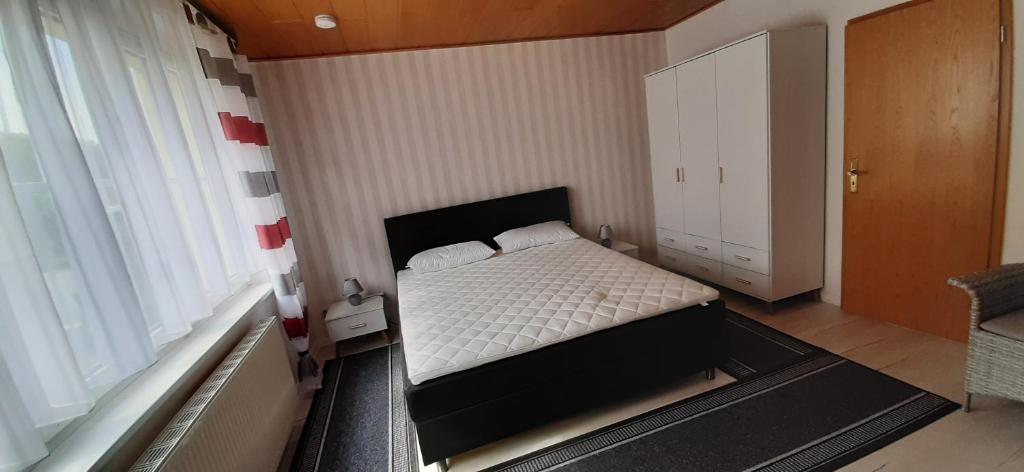 een kleine slaapkamer met een bed en een groot raam bij Ferienwohnung Lewitztor in Plate