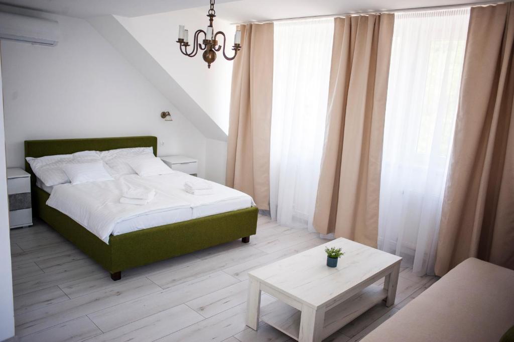 A bed or beds in a room at Q-Panzió