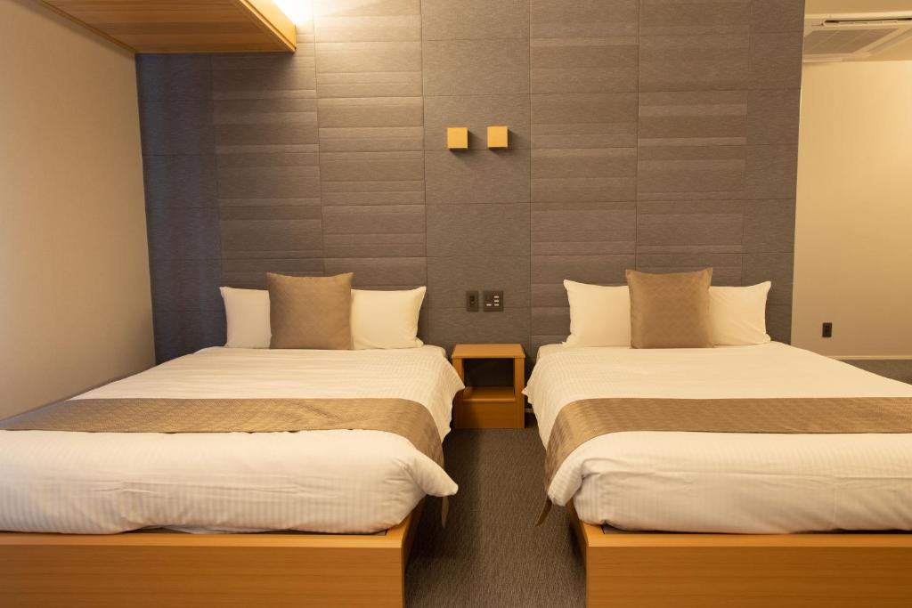 Postel nebo postele na pokoji v ubytování GRAND BASE Nagoya Ekinishi