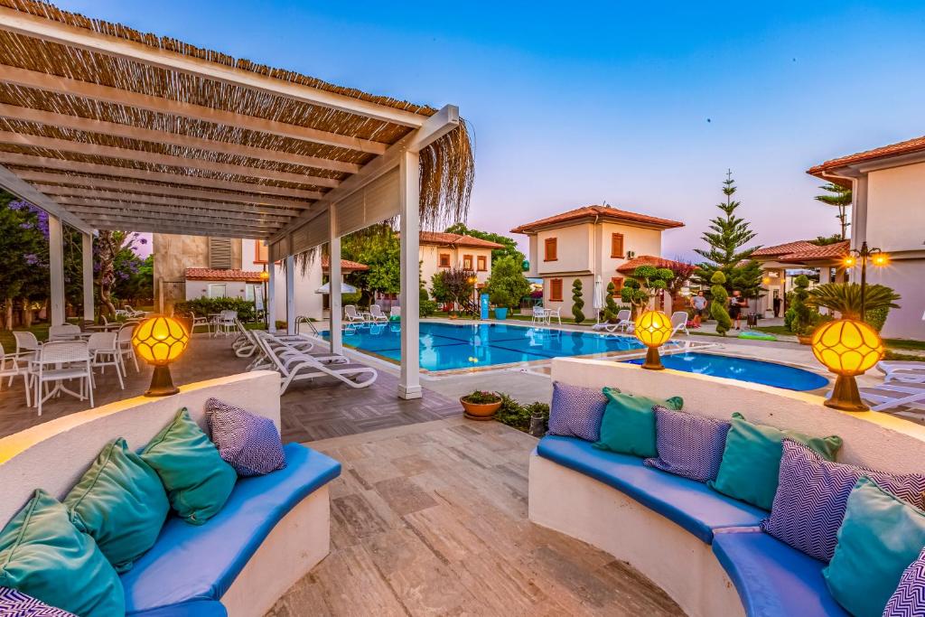 a patio with blue and purple pillows next to a swimming pool at Vista Villas in Belek