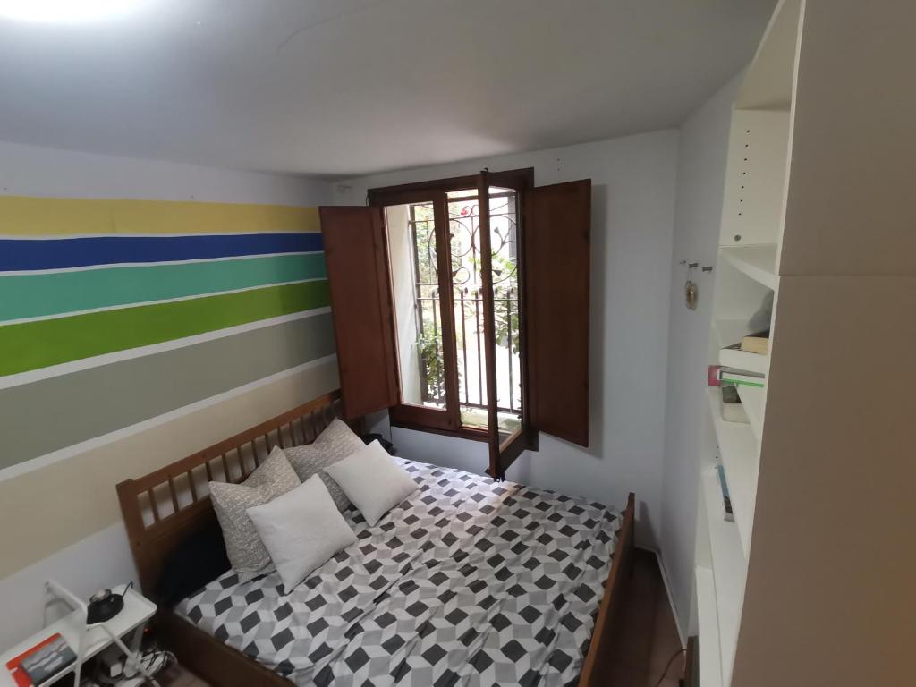 - un petit lit dans une chambre avec fenêtre dans l'établissement La villa Mektoub, à Badalona