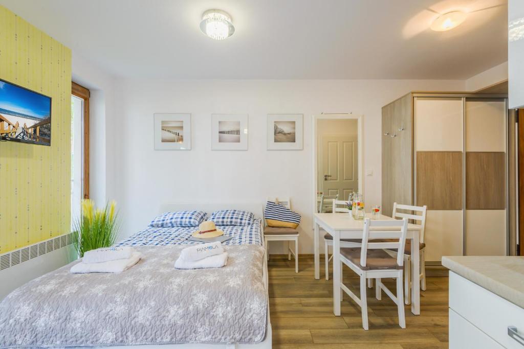 Cozy bedroom-dining area with double bed, small table and wardrobe, minimalist styling