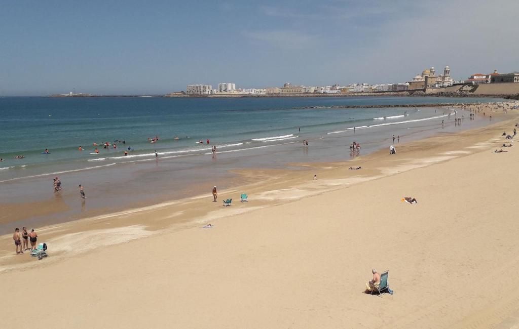 un grupo de personas en una playa con el océano en La Nube de San Miguel, en Cádiz