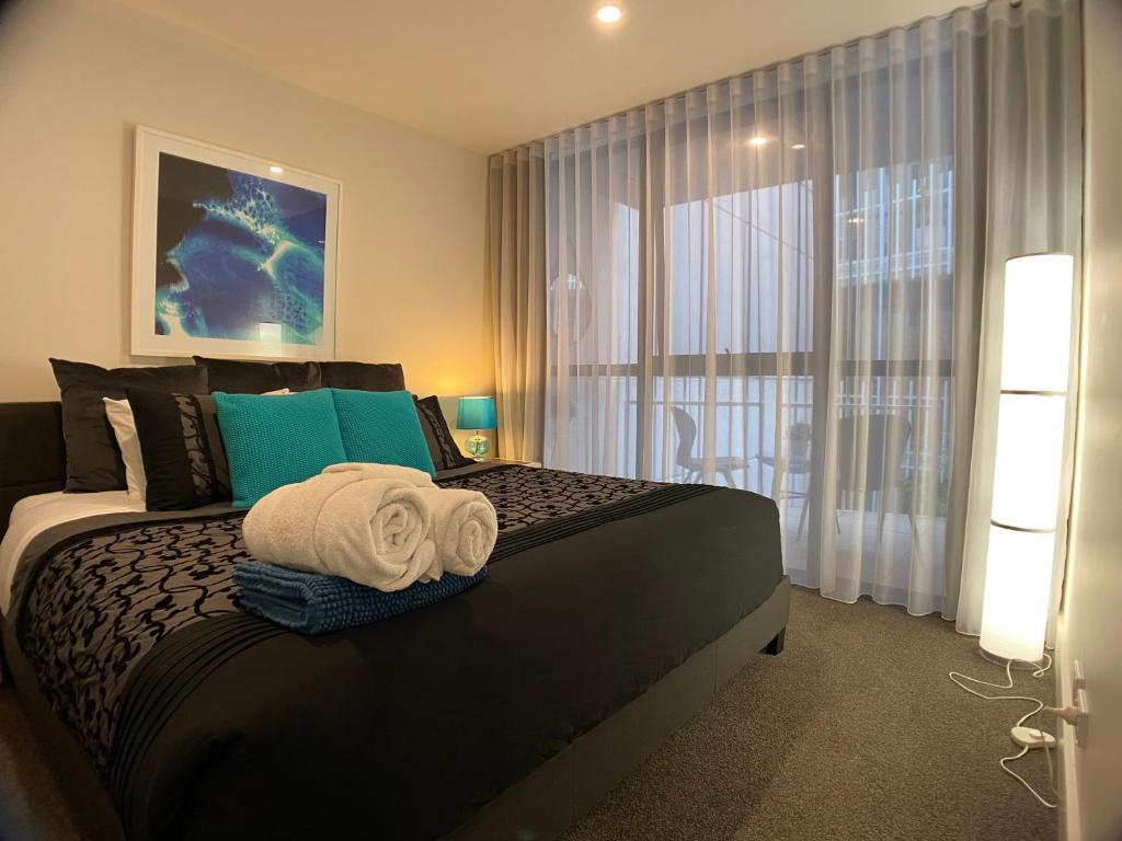 The Gallery Luxe 1 BR Executive Apartment in the heart of Braddon Wine Secure Parking WiFi في كانبرا: غرفة نوم بسرير كبير ونافذة