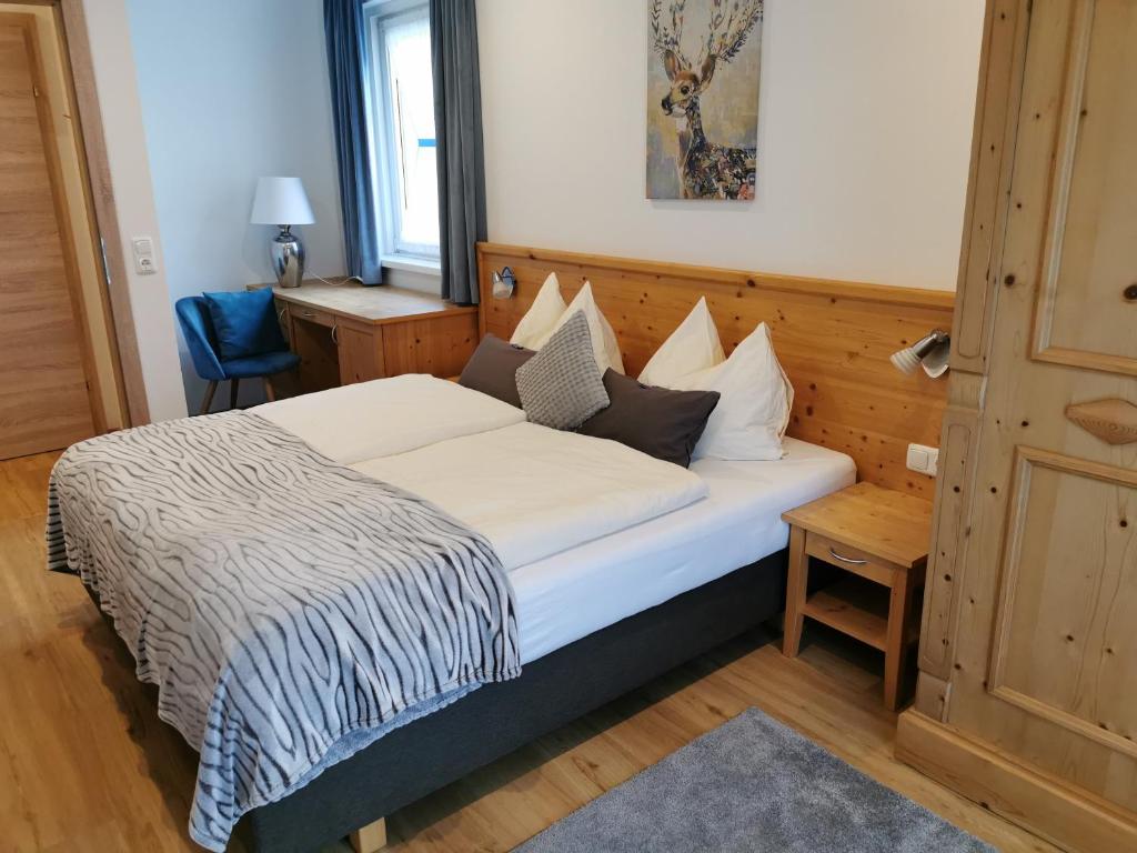 a bedroom with a bed and a blue chair at Apartmenthaus WALDHORN in St. Wolfgang