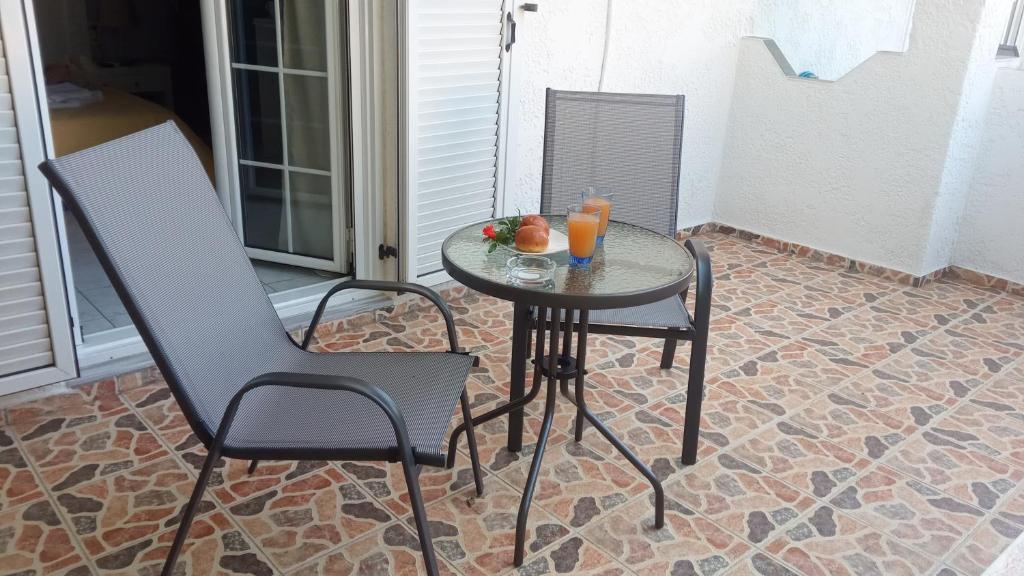 a small table with two chairs and two drinks on it at Sivotahomes-blu in Syvota