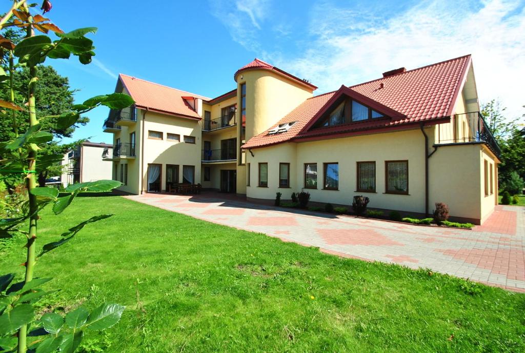 una casa grande con un césped verde delante de ella en Willa Chantal, en Jastrzębia Góra