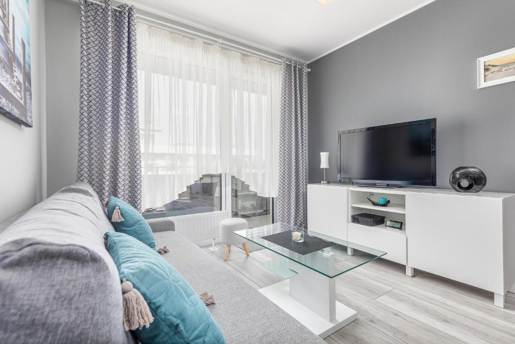 Televízia a/alebo spoločenská miestnosť v ubytovaní Apartamenty Osiedle Bursztynowe III by Noclegi Renters