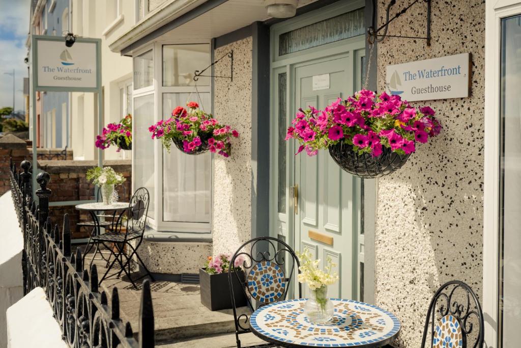 a balcony with a table and chairs and flowers at The Waterfront in Dingle