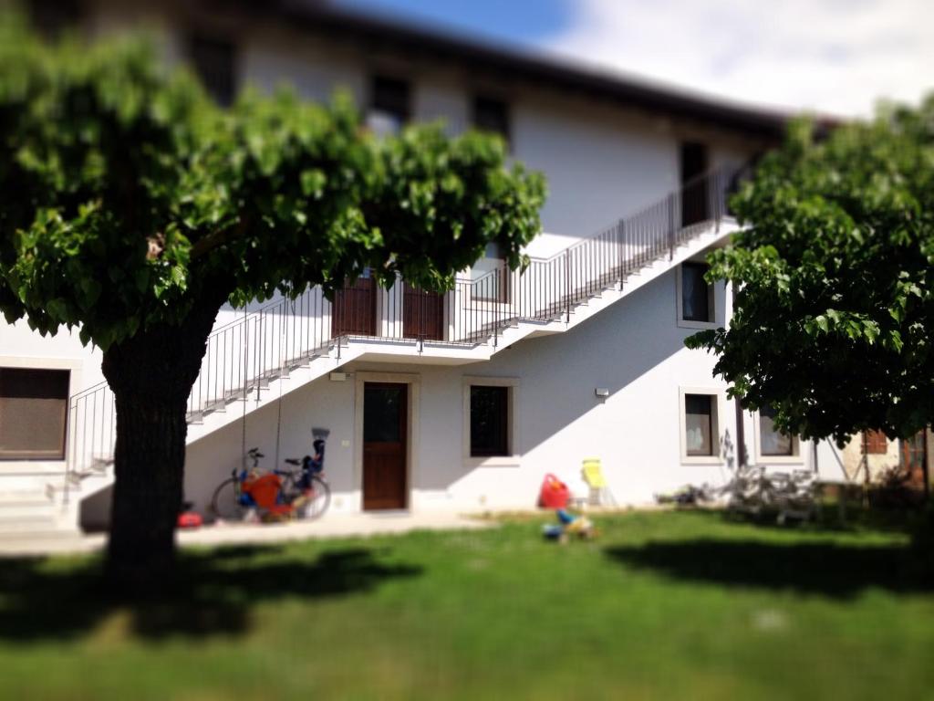 una casa blanca con un árbol en el patio en Casa Romea, en Cividale del Friuli