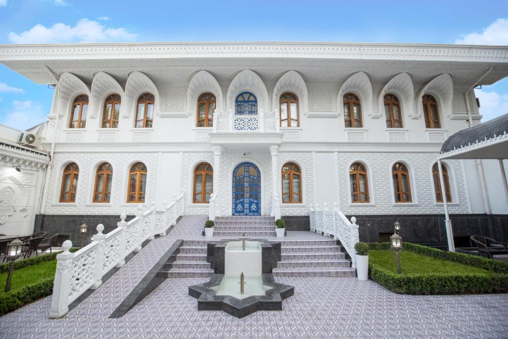 a large white building with stairs in front of it at The Shahar in Tashkent