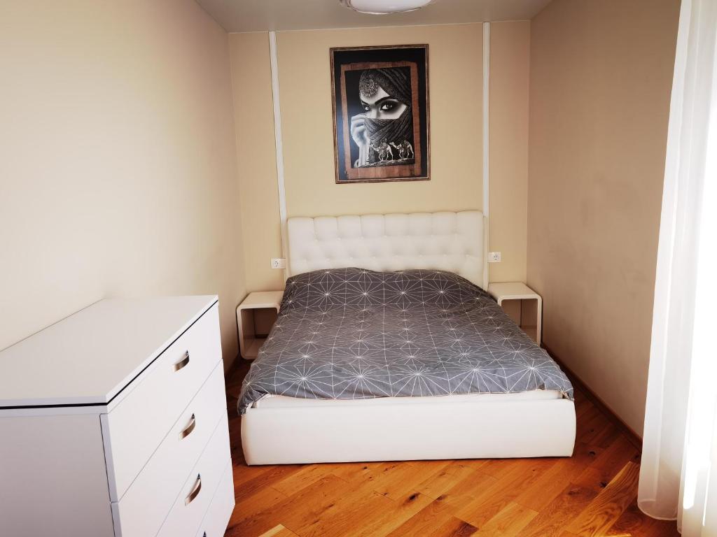 a small bedroom with a bed and a dresser at Bangų g. Apartamentai in Klaipėda