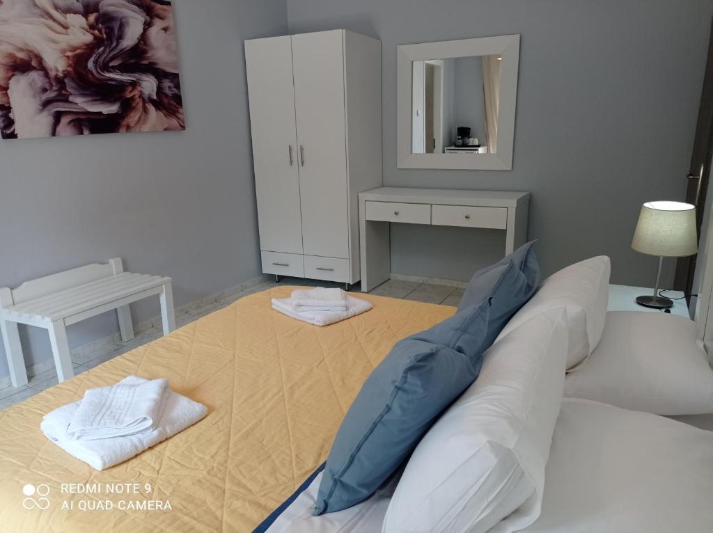 a living room with a bed and a mirror at Sivotahomes-blu in Syvota
