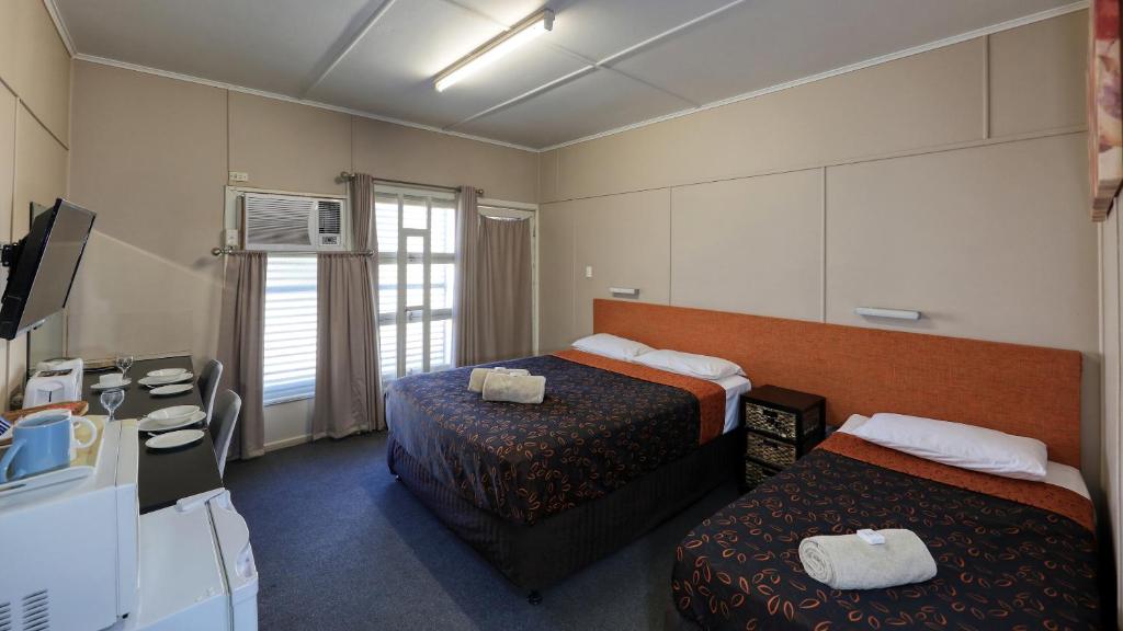 a hotel room with two beds and a desk at Matilda Motel in Winton