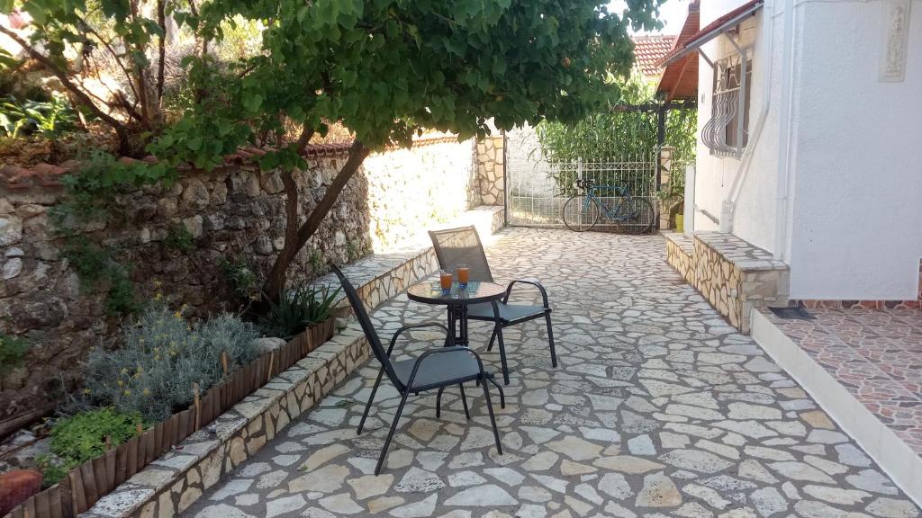 a patio with two chairs and a table in a yard at Sivotahomes-blu in Syvota