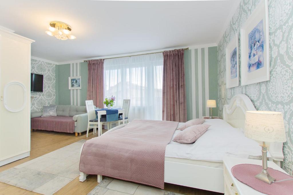 a bedroom with a bed and a living room at Willa Aquarius in Karwia