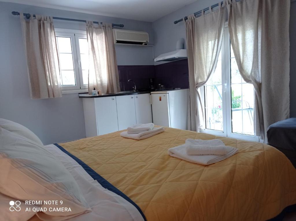 a bedroom with a large bed with two towels on it at Sivotahomes-blu in Syvota