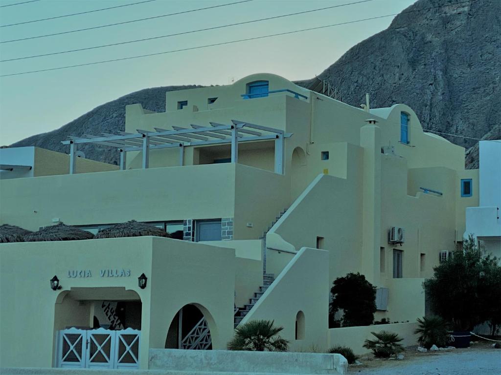 a building with a mountain in the background at Lucia Villas in Perissa