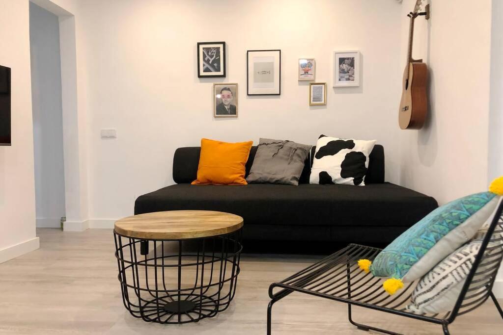 a living room with a black couch and a table at M5 Cool Terrace. Metro 1 min. Center 15' by metro in Esplugues de Llobregat