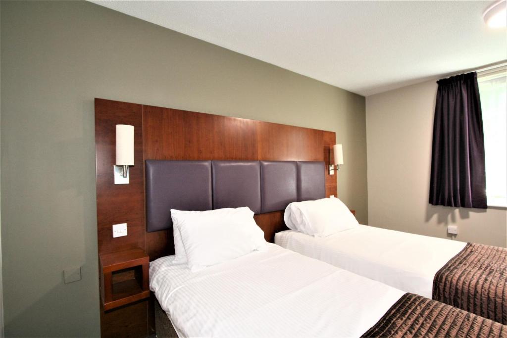 Postel nebo postele na pokoji v ubytování The Oakwood Hotel by Roomsbooked