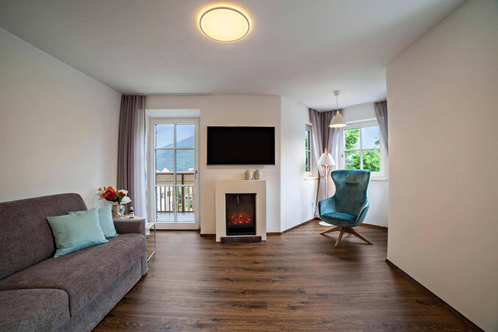 a living room with a couch and a fireplace at Engel Appartements Erker in Parcines