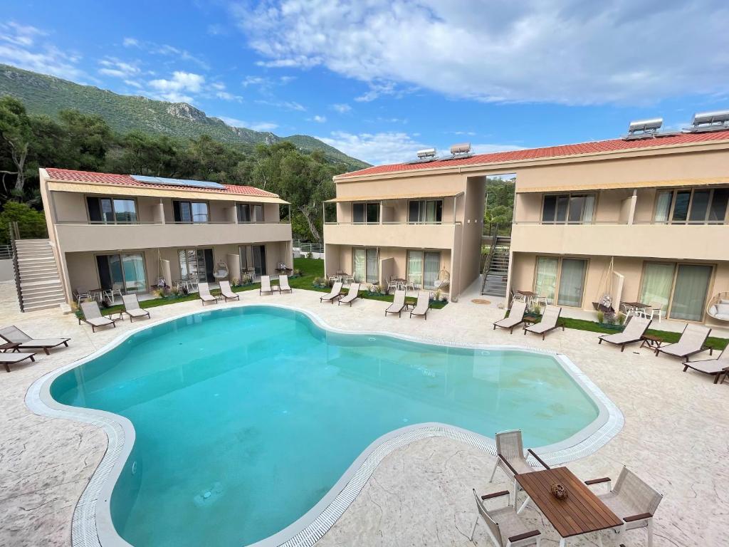 een zwembad in een hotel met stoelen en een resort bij Scarabeo Hotel & Villas Parga in Parga