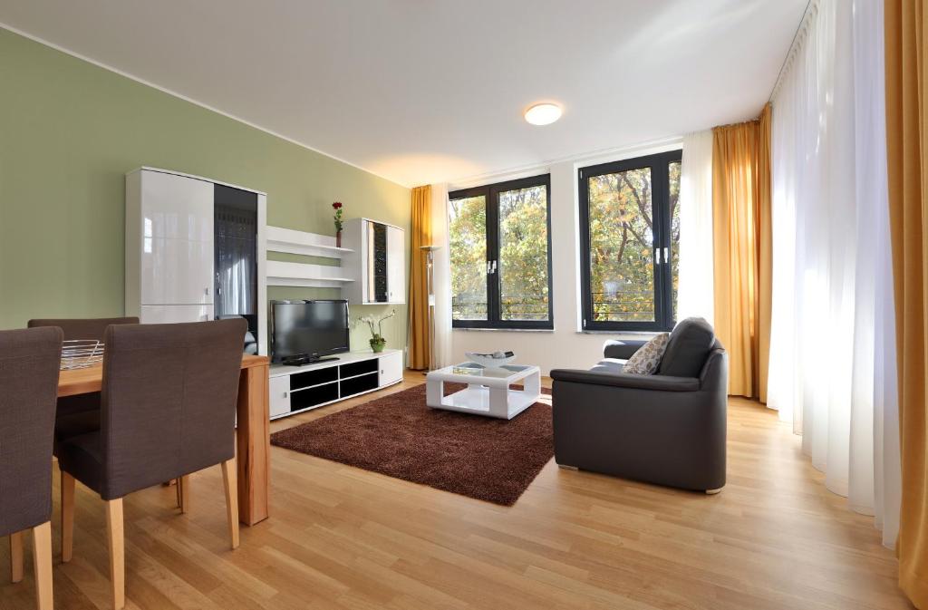 a living room with a dining table and a television at Business Suiten in Munich