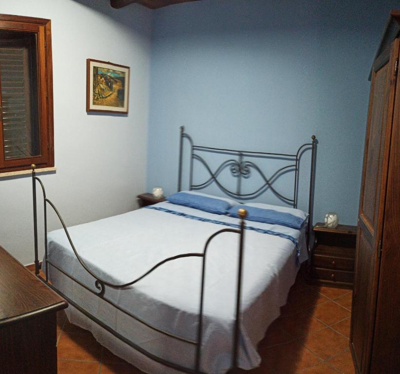 1 dormitorio con 1 cama en una habitación azul en Casa vacanze BY THE SEA, en Trabia