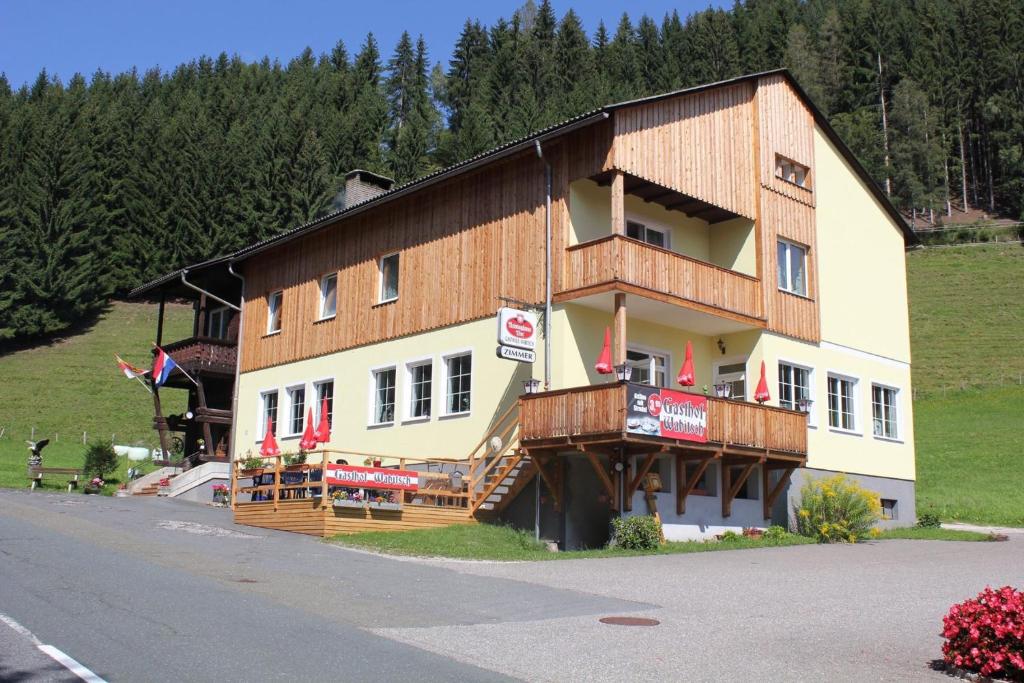 ein großes Holzgebäude mit einem Balkon an der Straßenseite in der Unterkunft Gasthof Wabitsch in Kliening