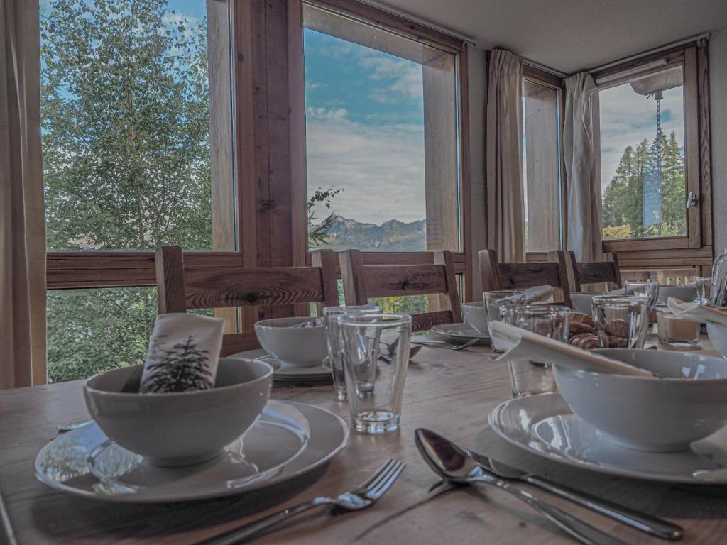 una mesa de madera con platos y cuencos encima en La Belle Maison en Peisey-Nancroix