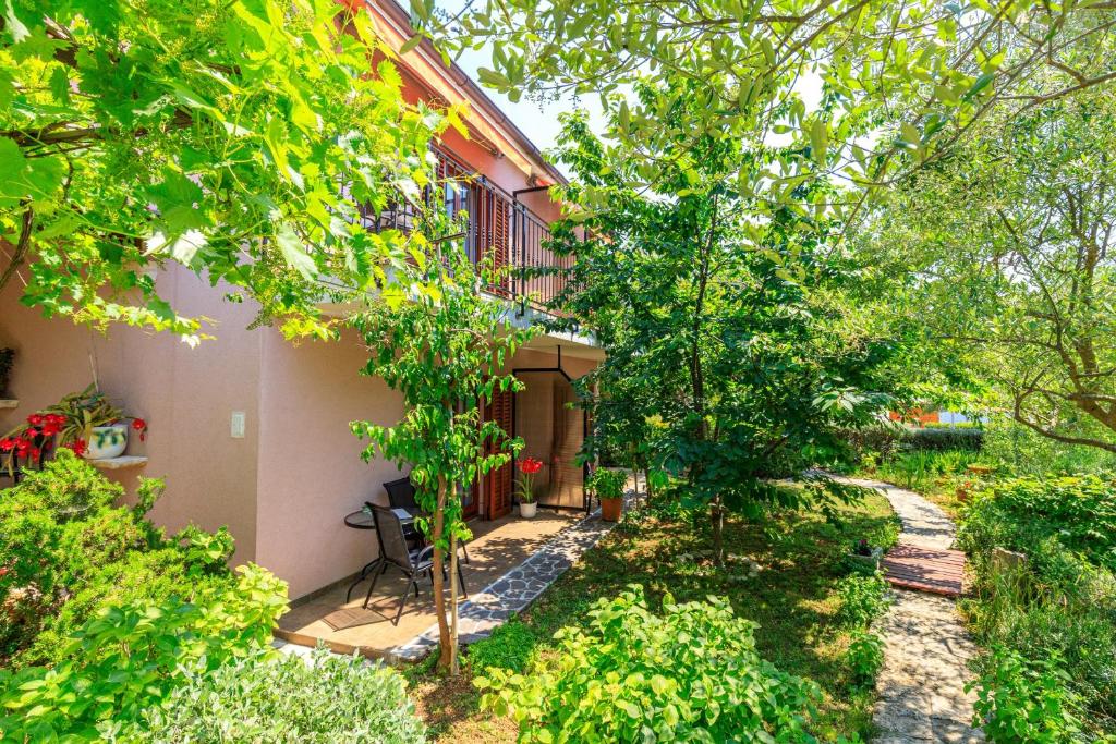 un jardín con árboles y un edificio en Apartments Lavanda, en Rovinj