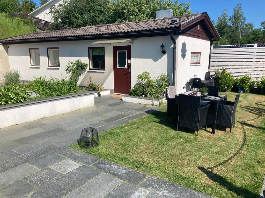 una casa con mesa y sillas en el patio en Casa Tureholm - ett mysigt hus i idylliska Trosa, en Trosa