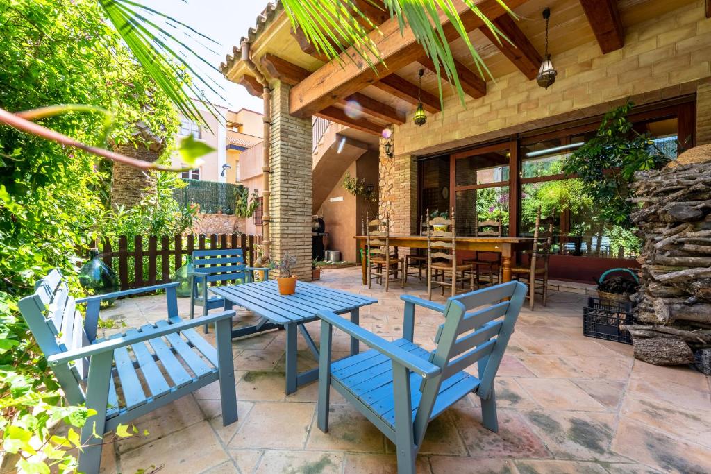 a patio with two blue chairs and a table at Hauzify I Palauet del Remei in Perelló