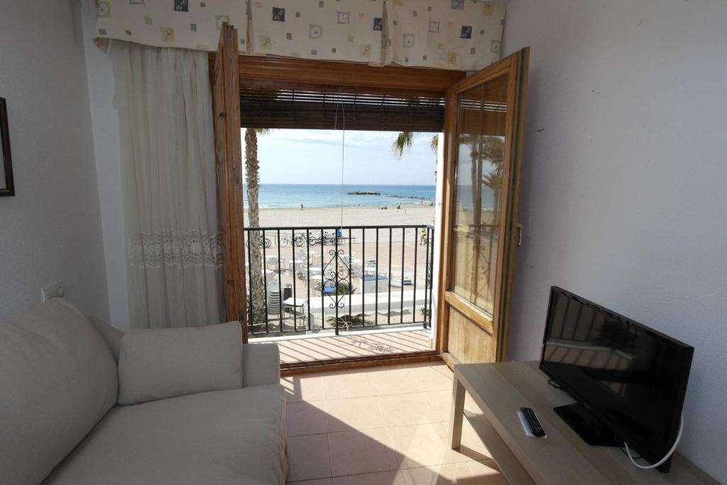 sala de estar con sofá y vistas a la playa en AR1B, Acogedor estudio a pie de playa, en Villajoyosa