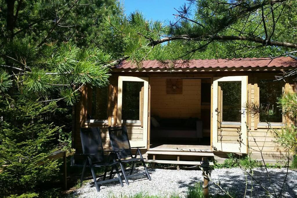une petite cabine avec deux chaises devant elle dans l'établissement Cozy Lodge in Värmland Sweden, à Filipstad