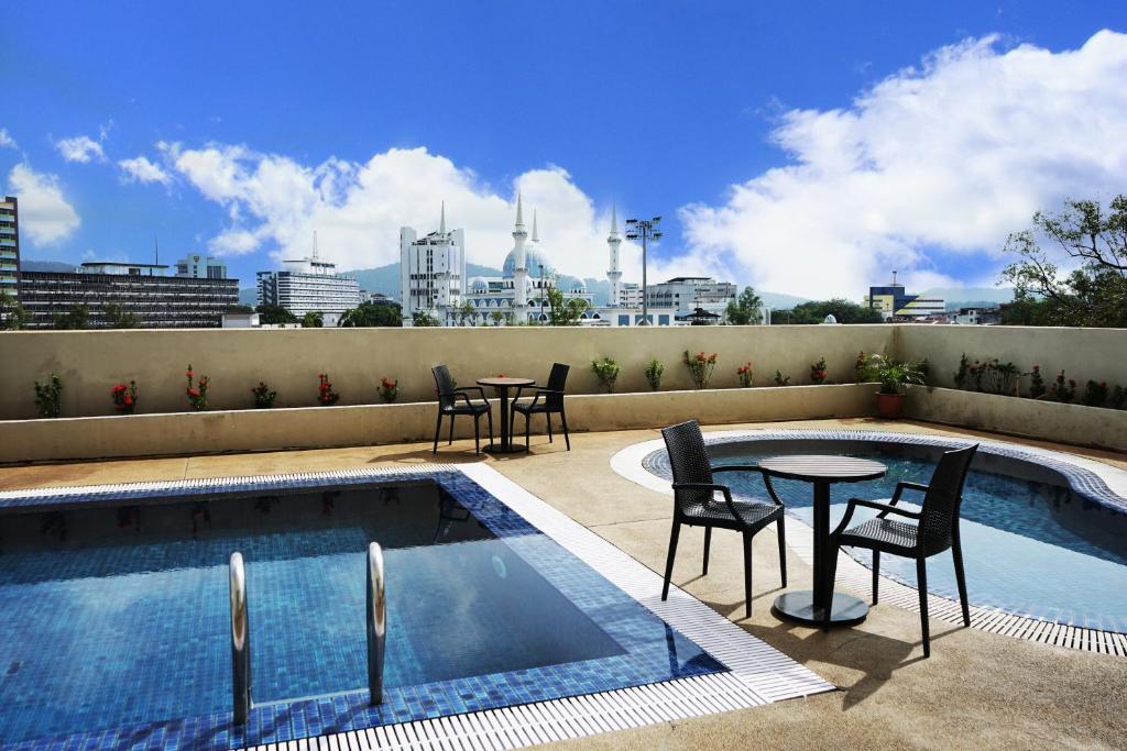 uma piscina com cadeiras e mesas num telhado em Shahzan Hotel Kuantan, Trademark Collection by Wyndham em Kuantan