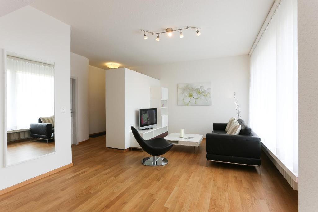 sala de estar con sofá y silla en Serviced Apartments Haus 2, en Uzwil