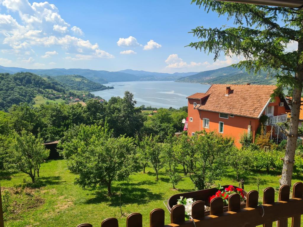 een huis op een heuvel met uitzicht op een meer bij Apartmani Kuljanin in Donji Milanovac