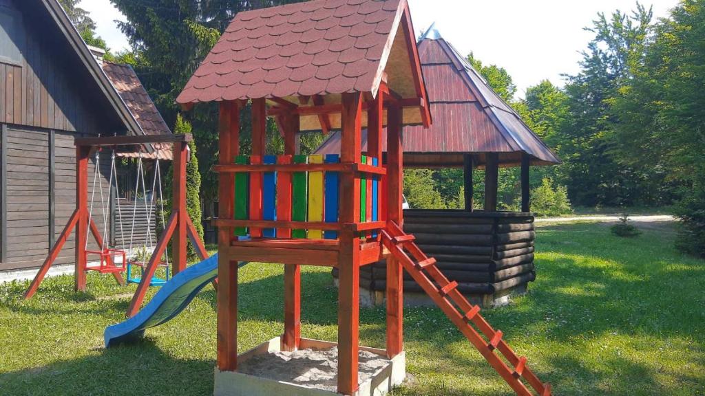 einen Spielplatz mit Rutsche und Spielstruktur in der Unterkunft Vikendica na Sokolini in Gornja Koprivna