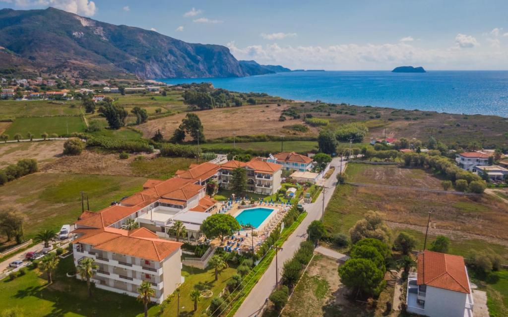 an aerial view of a house with a pool and the ocean at Denny's Inn in Kalamaki