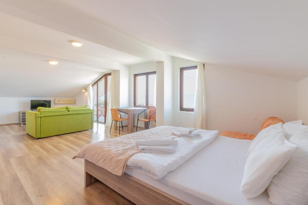 a white bedroom with a large bed and a living room at Et Larum in Peštani