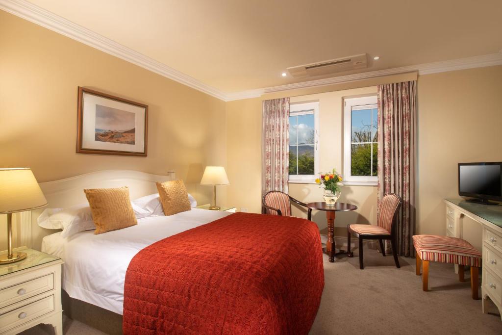 キラーニーにあるキラーニー ロッジのベッドとテレビが備わるホテルルームです。
